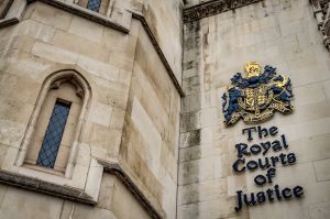 The facade of the Royal Courts of Justice in London, England showing the coat of arms of the courts and architectural details (Demo) executors insurance policy